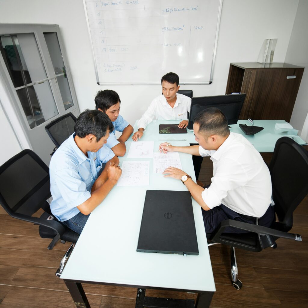 pexels-photo-17382268-17382268 Four professionals discuss plans around an office table, fostering collaboration and teamwork.